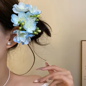 Gros plan détaillé d'une pince à cheveux à fleurs en tissu bleu et blanc sur le côté