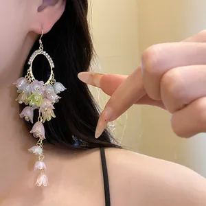 Close-up of elegant floral tassel earrings with colorful resin lily of the valley flowers
