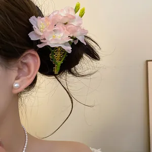 Détail d'une élégante pince à cheveux avec fleur en tissu rose portée sur un chignon