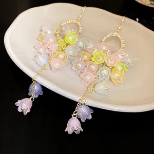 Detailed view of sweet forest style floral tassel earrings with pearls and rhinestones.