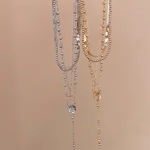 Detailed view of multi-layered cross and medallion necklaces in gold and silver finish