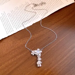 Detail of silver stainless steel necklace with floral and rabbit pendant charms