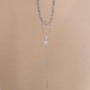 Detail view of a vintage silver layered necklace with elegant rhinestone cross pendants.