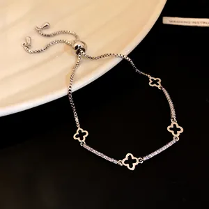 Dettaglio di bracciale regolabile in argento con ciondoli a quadrifoglio in zirconi