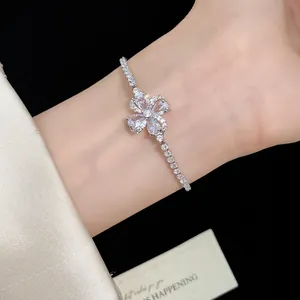 Primo piano di un elegante braccialetto con fiori a quattro foglie in zircone al polso