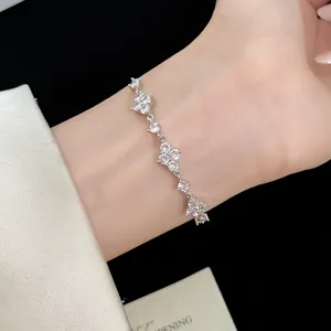 Dettaglio squisito di un bracciale scintillante in zircone argento con fiori di quadrifoglio