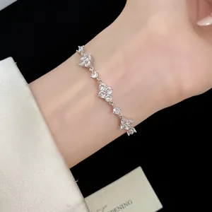 Primo piano di un braccialetto a quadrifoglio in zirconia cubica indossato al polso