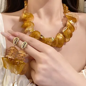 Vintage amberkleurige acryl ketting met onregelmatige kralen en schelpoorbellen op model