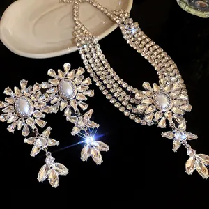 Close-up detail of sparkling rhinestone multi-layer necklace and matching floral earrings set.