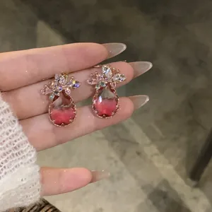 Gros plan d'élégantes boucles d'oreilles en zircon avec des pierres roses en forme de goutte.