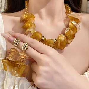 Detail van de dikke amberkleurige acryl gedraaide ketting en bijpassende oorbellen