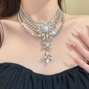 Close-up of multi-layered rhinestone necklace with pearl flower pendant on model.