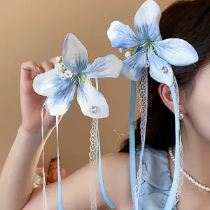 Detail showing elegant light blue fabric flower hair clips with lace and ribbon.