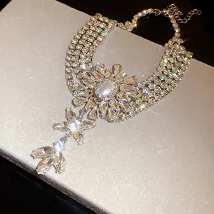 Detailed view of a multi-layer rhinestone necklace featuring a central pearl flower motif