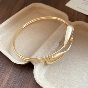 Close-up of vintage gold double-layer open bangle with water drop accents.