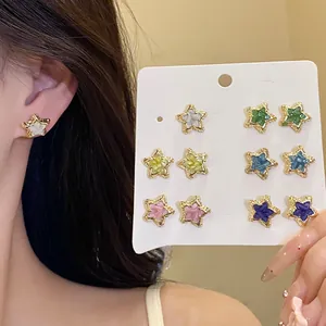 Detailed view of six pairs of colorful star-shaped stud earrings on display card