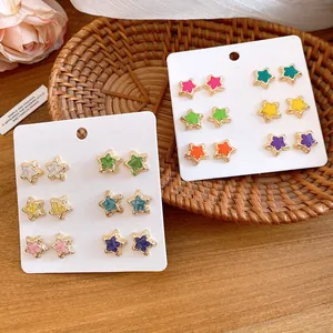Detailed macro view of colorful enamel star stud earrings set displayed on a white card.