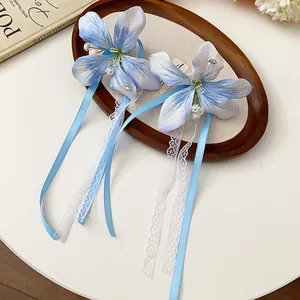 Close-up of blue fabric flower hair clips with elegant lace and ribbon details