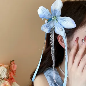 Close-up of elegant blue fabric flower hair clip with delicate lace and ribbons