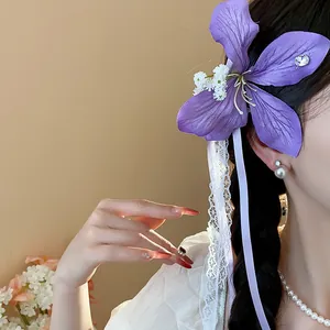 Close-up of elegant purple fabric flower hair clip with delicate lace and silk ribbons