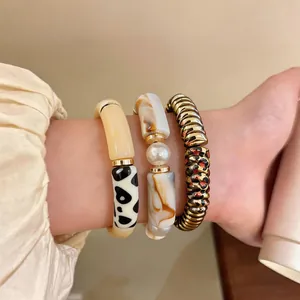 Close-up of stacked vintage acrylic leopard print and faux pearl bracelets for women
