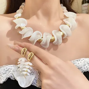 Detailweergave van witte acryl ketting met onregelmatige kralen en oorbellen set