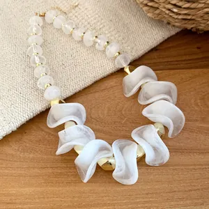 Detailopname van acryl onregelmatige kralenketting met elegante witte golfkralen.