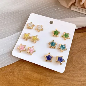 Close-up of 12-piece colorful enamel star stud earring set on white display card