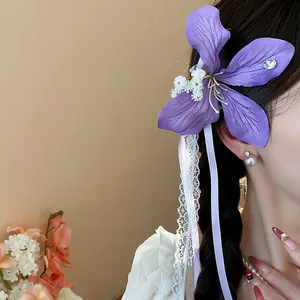 Exquisite purple fabric flower hair clip with delicate lace ribbons worn on side hair