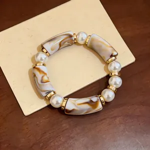 Vintage acrylic leopard print and pearl bracelet displayed on a tan card