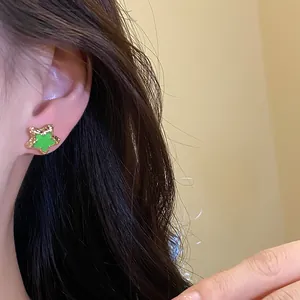 Detailed close-up showing a bright green drip oil star stud earring on an ear