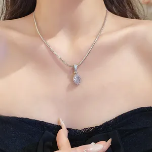 Close-up of fashion zircon pendant necklace on dainty snake chain, elegant collarbone style.