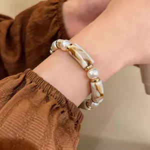Close-up of a vintage acrylic leopard print and pearl beaded bracelet on a woman's wrist