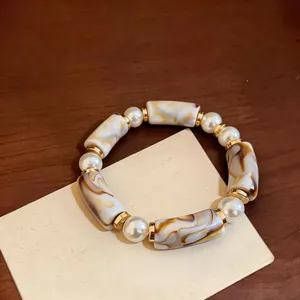Close-up of vintage acrylic leopard print beads and pearls on an elegant bracelet.