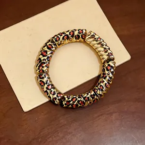 Close-up of retro acrylic bracelet with gold twisted texture and leopard print segments