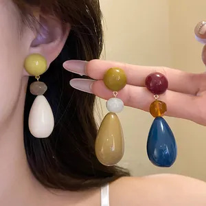 Detailed view of colorful resin teardrop earrings in a retro and minimalist fashion style