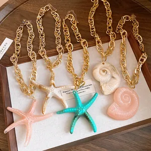 Detailed view of acrylic starfish and conch pendant necklaces with chunky gold chains