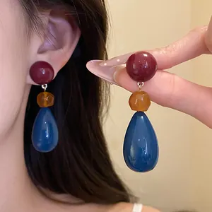 Macro view of stylish vintage resin drop earrings with red, orange, and blue beads