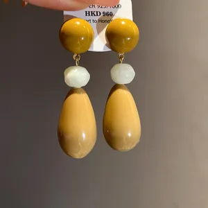 Close-up view of vintage mustard yellow resin teardrop earrings with S925 silver needles