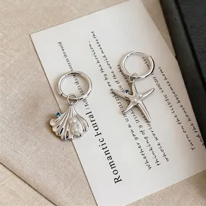 Asymmetric starfish and shell earrings with pearls and blue zircons on silver hoops