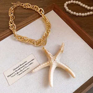 Detail shot of a vintage starfish pendant necklace with a chunky gold link chain