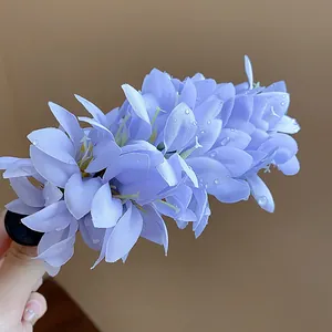 Macro detail of purple fabric flower hair clip with realistic water droplets decoration