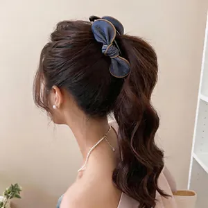 Elegant denim fabric bow hair clip on model ponytail with pearl jewelry