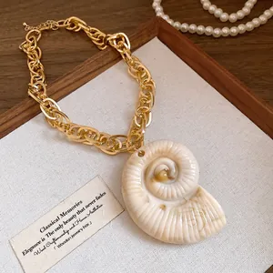 Detailed view of retro acrylic nautilus shell pendant with golden chunky chain links