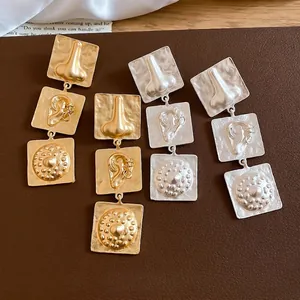 Unique geometric earrings with embossed facial features in gold and silver finish