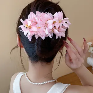 Detail view of an elegant pink artificial flower hair clip with lifelike dew drops