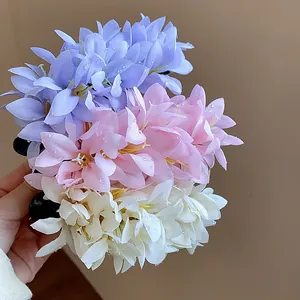 Close-up of pastel purple, pink and white fabric flower hair clips with water drops