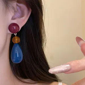 Macro detail of vintage resin teardrop earrings with multi-color splicing