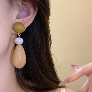 Close-up of vintage resin teardrop earrings featuring an elegant three-tier bead design.