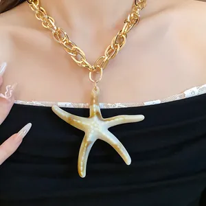 Close-up of a vintage acrylic starfish pendant necklace with a chunky gold chain.